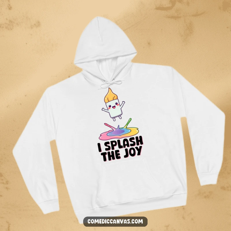 Funny hoodie showing a happy, kawaii paintbrush leaping joyfully between colorful paint puddles, perfect for staying warm and inspired.